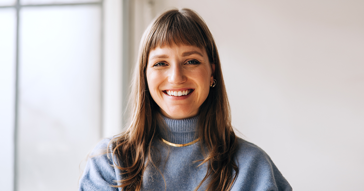 Glad person som ler i kameran