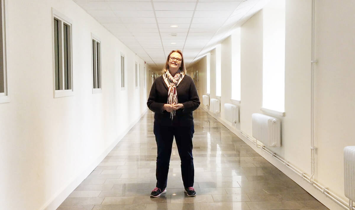 Kvinna med självförtroende står i mitten av en korridor.
