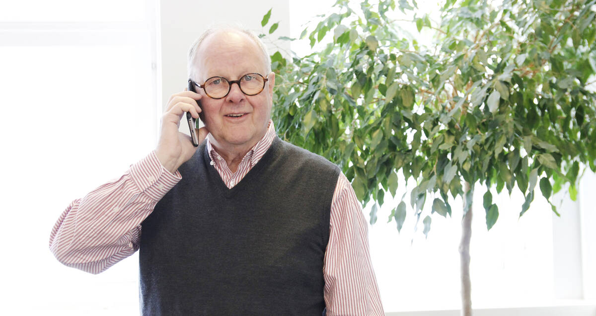 Äldre glad herre talar i mobiltelefonen.