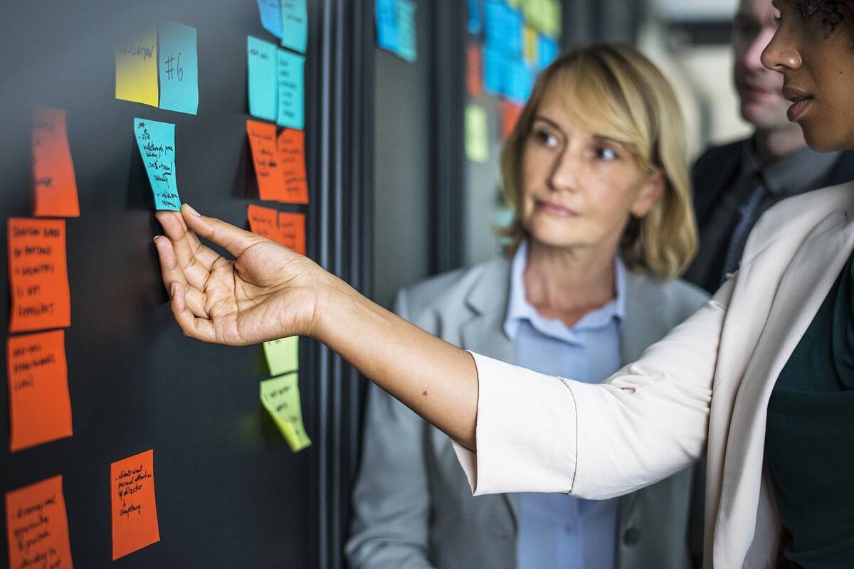 Foto på personer som sittar på uppsatta post-it-lappar