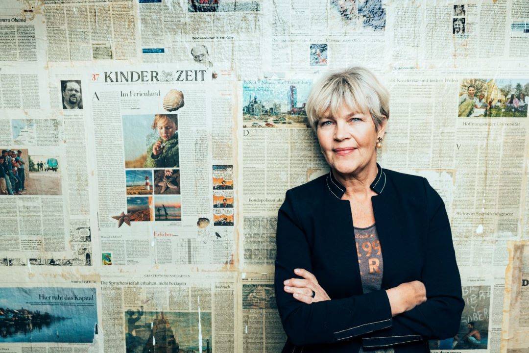 Bild på Åsa Lundquist Coey framför tidningsvägg