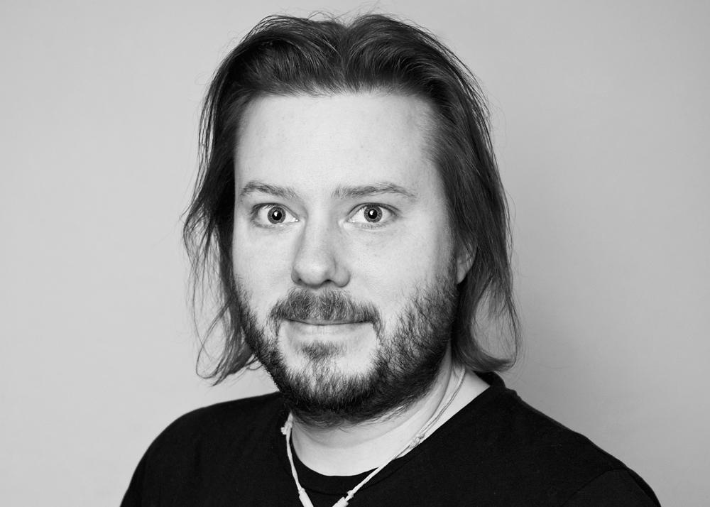 Bild på fältassistenten Martin Eidensten, som har svart t-shirt, halvlångt hår och skägg.