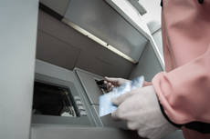 16308103-man-at-atm-machine-with-stash-of-credit-and-debit-cards.jpg