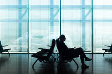 12275760-woman-in-transit-waiting-on-airport-gate.jpg