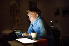 42798518-concentrated-young-man-working-night-at-home-office-with.jpg