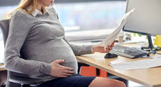 21006730-pregnant-businesswoman-reading-papers-at-office.jpg