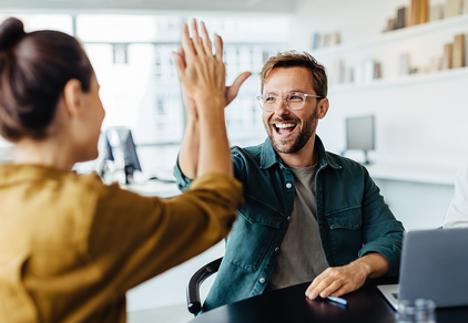 kvinna och mna highfivear i kontorslandskap